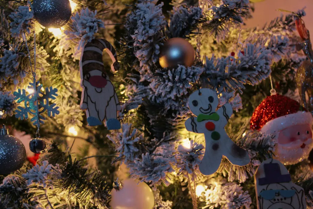 two rustic handmade christmas ornaments hanging in a christmas tree