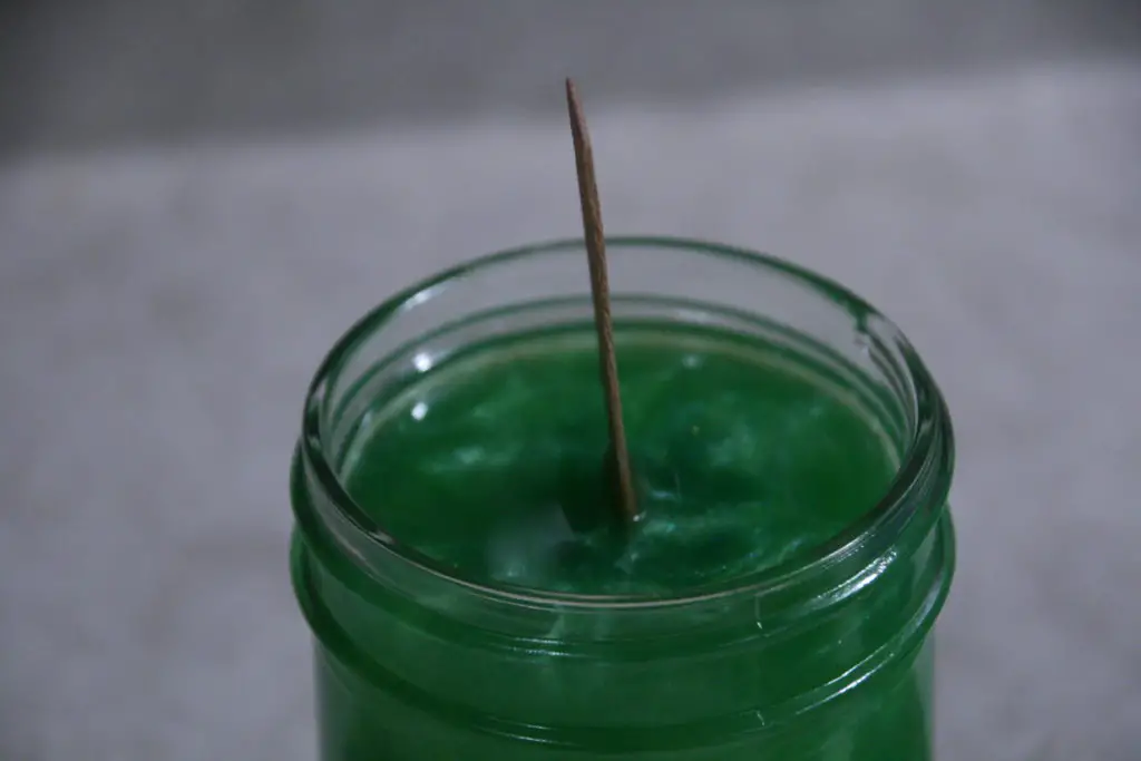 green colored soy wax poured into the mason jar