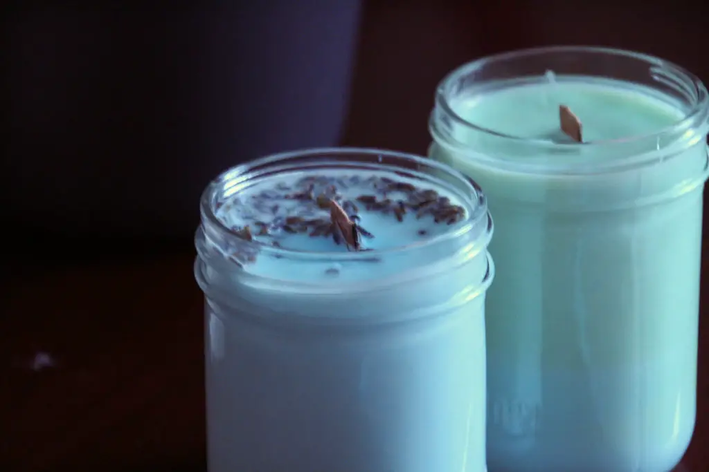 two soy wax candles in mason jars with wooden wicks