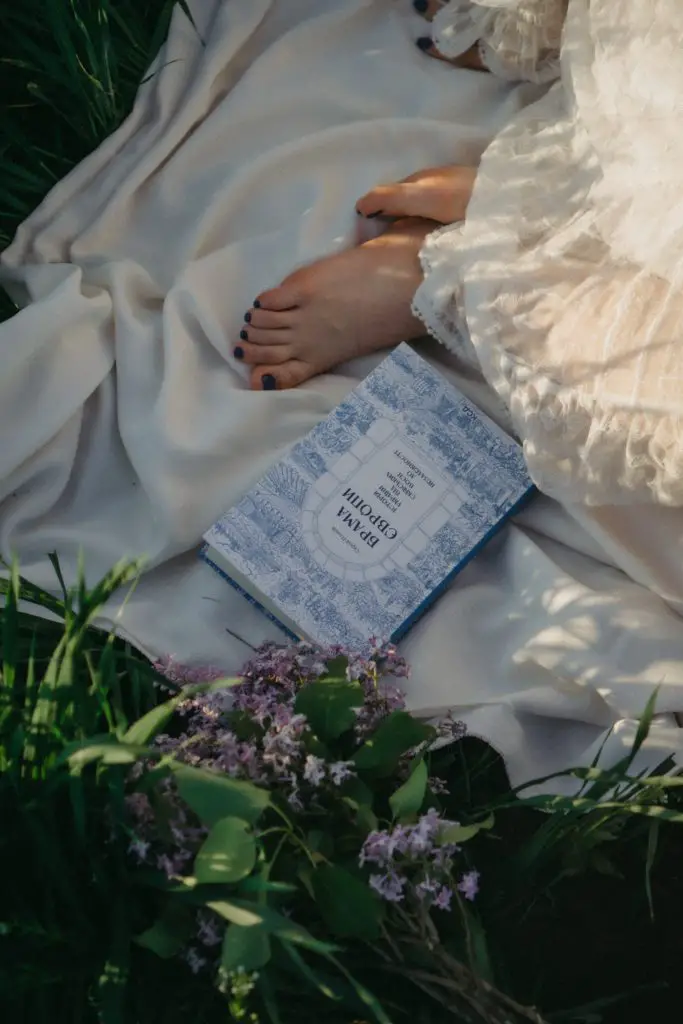 reading a romance novel on a blanket outside in the spring