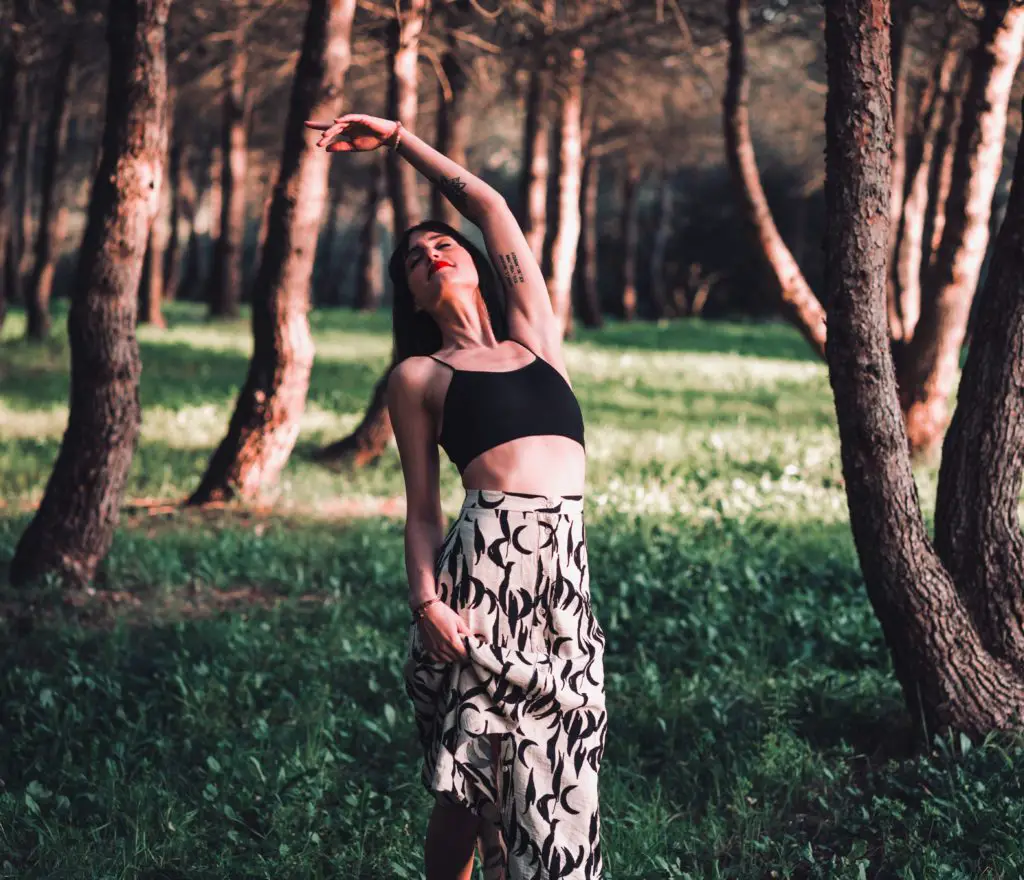 a photo of a woman dancing freely in the forest