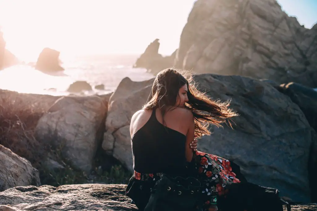 This woman sitting outside on a rugged mountain top doesnt feel left out, or FOMO, by choosing to follow her own path.