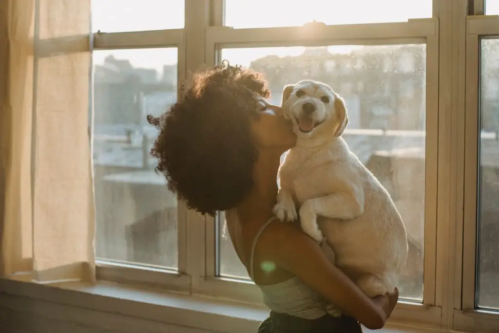 This woman picking up her dog, spending quality time doing what she loves, is prioritizing what matters.