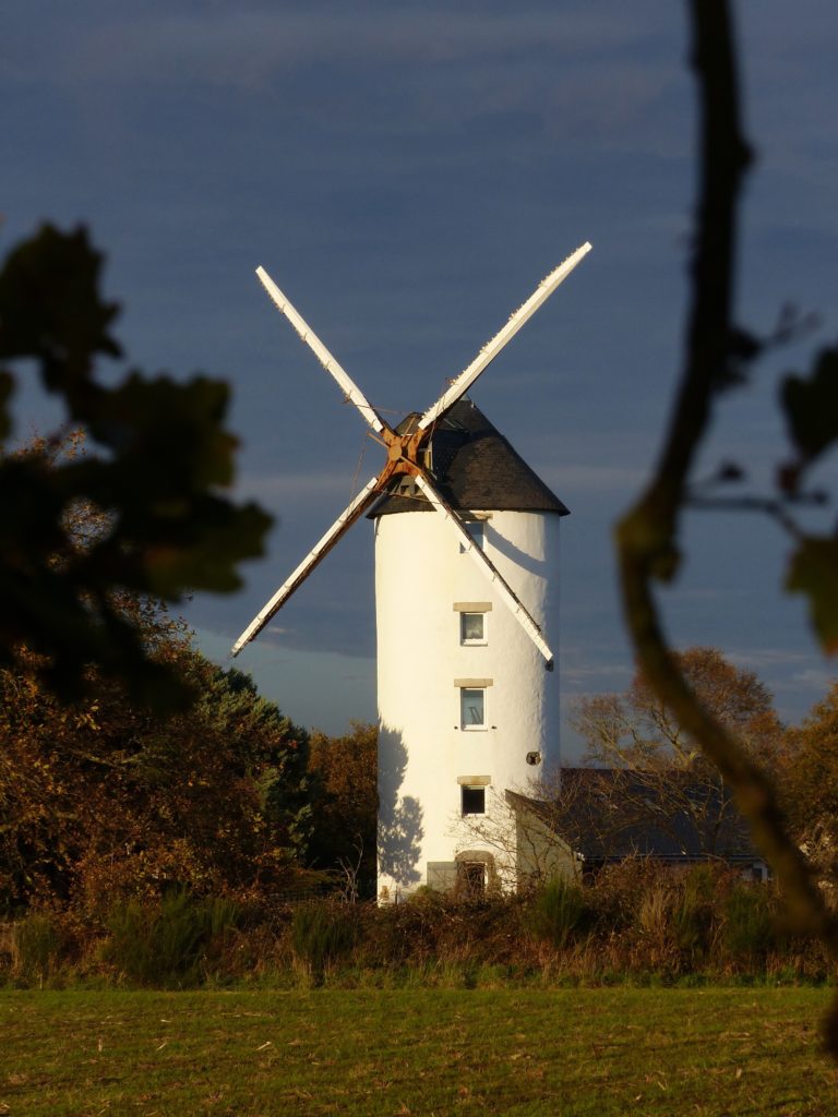 A windmill in a grassy field in France