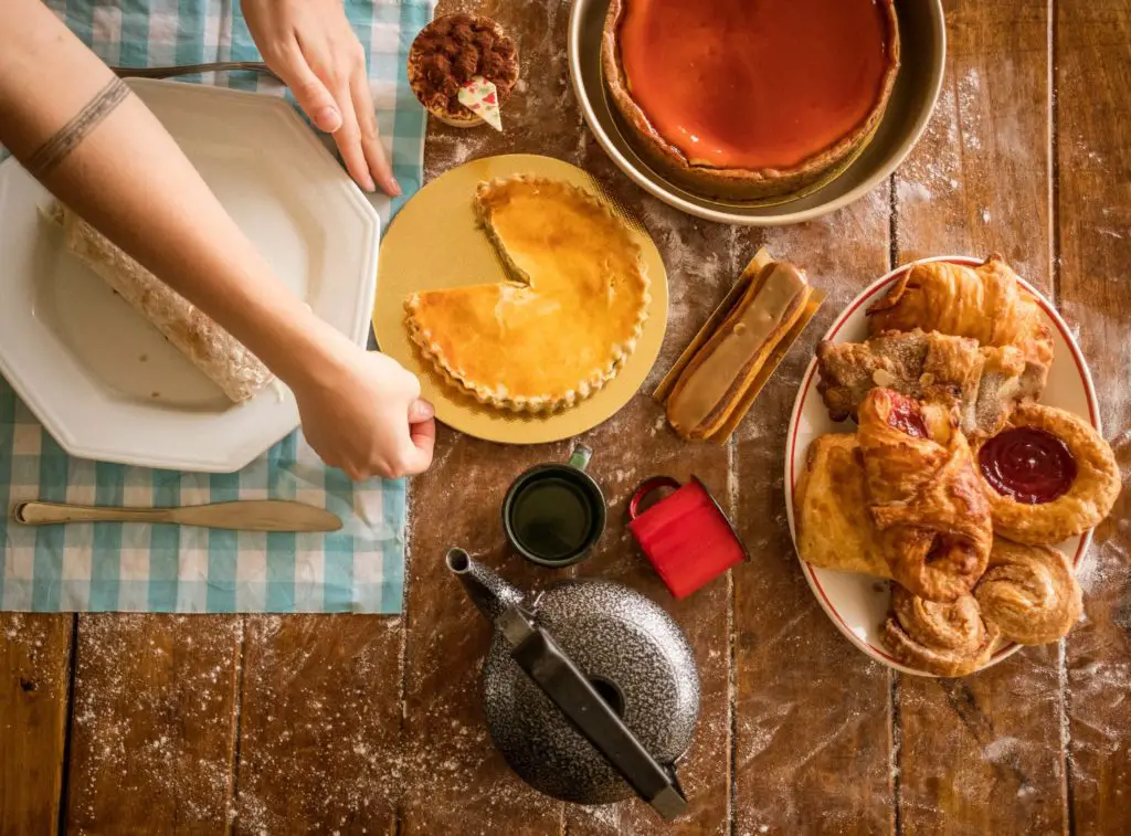 yumm desserts on a cozy cottagecore table, including pumpkin pie and pastries.