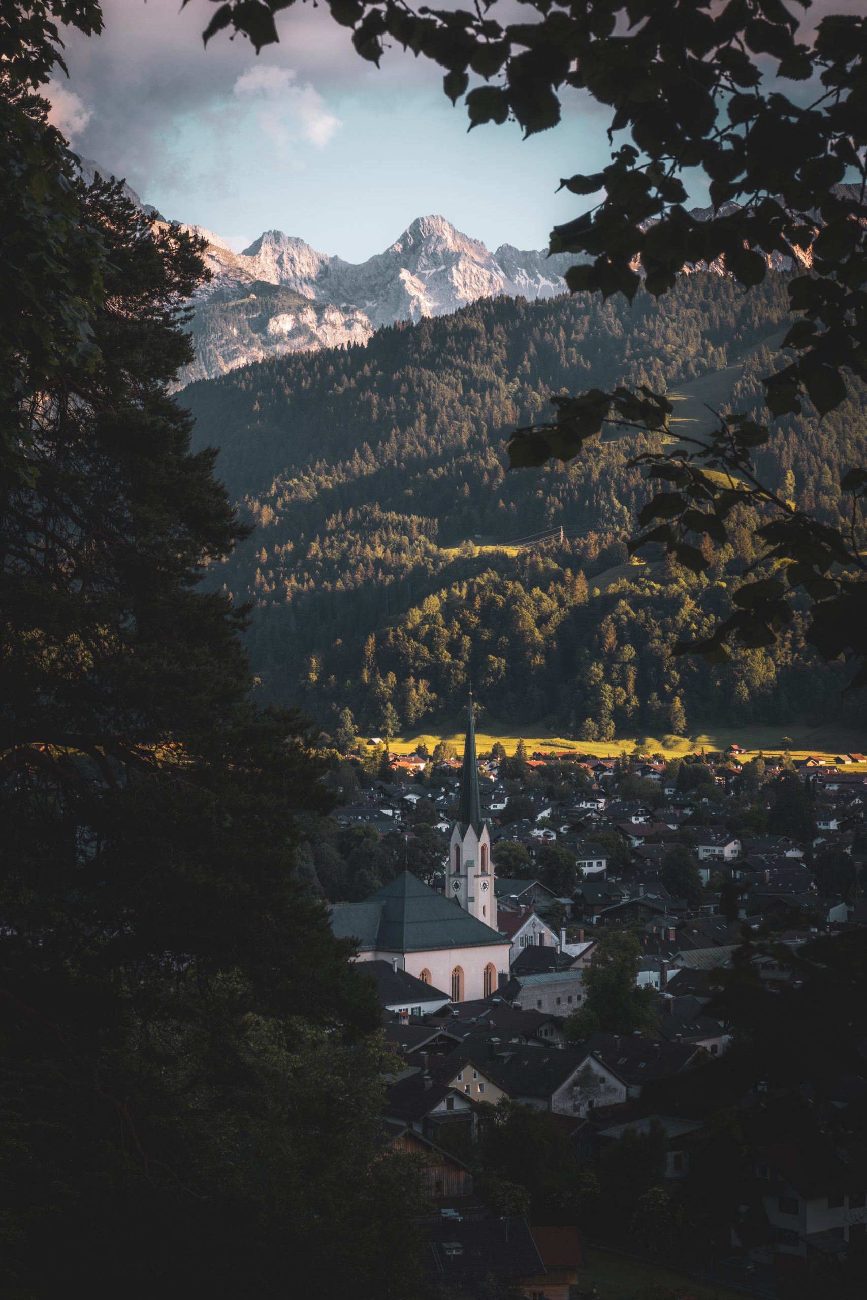 A beautiful scenic village in Germany featuring mountains and a church.