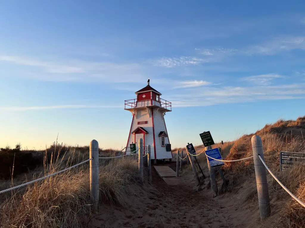 This photo shows a lighthouse amongst sandy dunes in PEI, Canada.